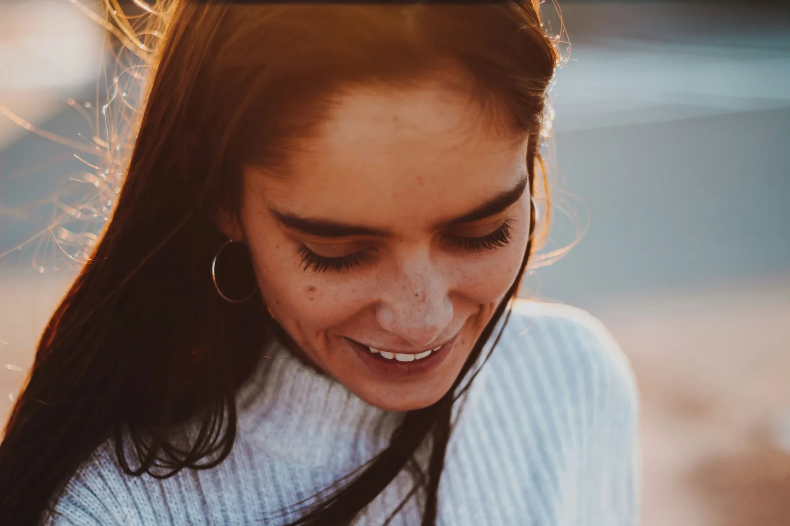 A woman smiling and looking down